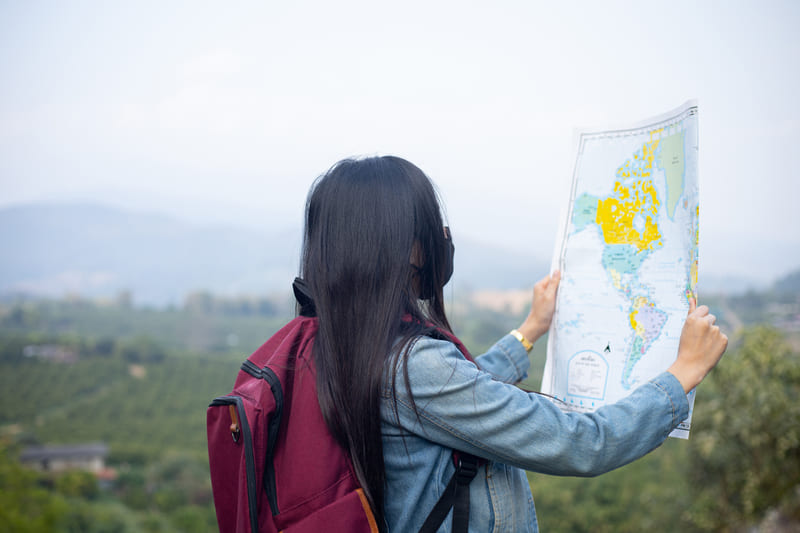Seorang traveler sedang melihat peta saat wisata di Jogja.