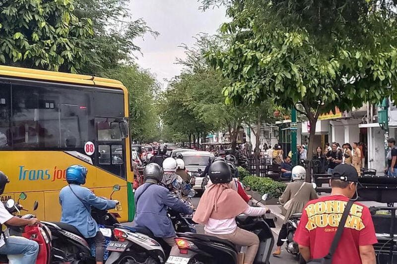 Wisatawan mengendarai motor matic melintasi kawasan Jalan Malioboro Yogyakarta